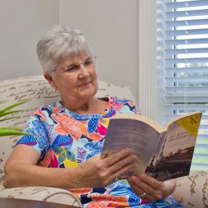 Senior reading a book in her senior living community