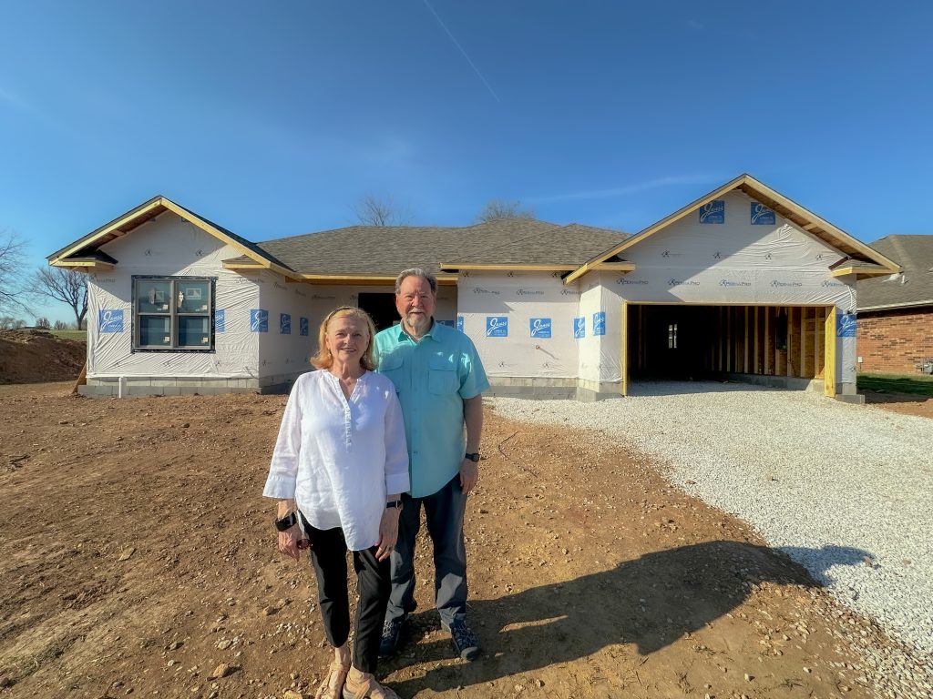 The Merrels in front of their new home being built at Maranatha Village.