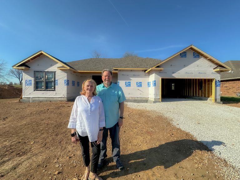 The Merrels in front of their new home being built at Maranatha Village.